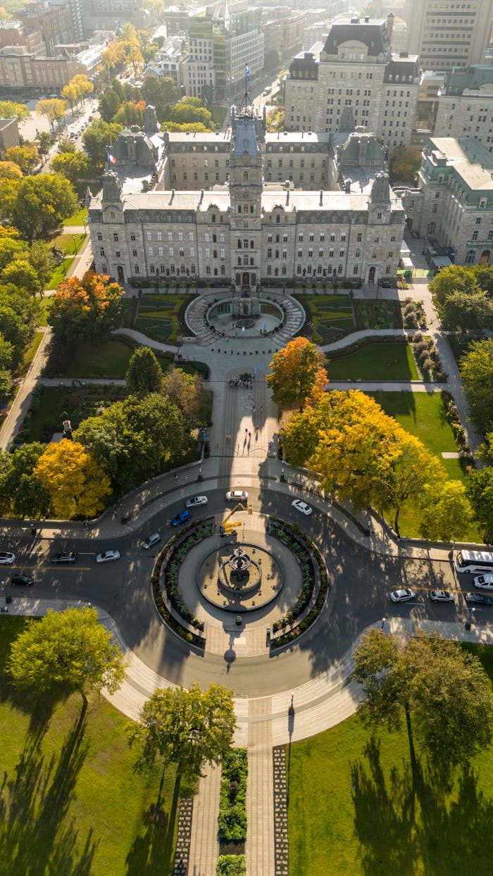 Stunning aerial shot of Quebec's Parliament building surrounded by vibrant fall foliage and cityscape.
